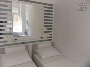 two white beds in a room with a window at Luxurios and historic apartment "Shine" - right on the Main Square in Zagreb