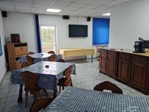 Un comedor con mesas y sillas y un televisor. en ViiLaEne, en Deta