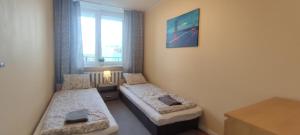 een kleine kamer met 2 bedden en een raam bij Labo Apartment Platynowa in Warschau