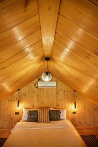 a bed in a room with a wooden ceiling at Scandinave Chalet Bran in Zărneşti