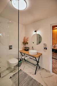 a bathroom with a toilet and a sink and a mirror at Scandinave Chalet Bran in Zărneşti