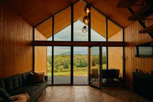 a living room with a large glass door with a view at Scandinave Chalet Bran in Zărneşti
