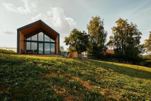 a house on top of a grassy hill at Scandinave Chalet Bran in Zărneşti