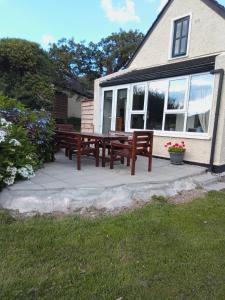 two wooden benches sitting on a patio in front of a house at 43 Reidhlean Clifden Glen in Clifden