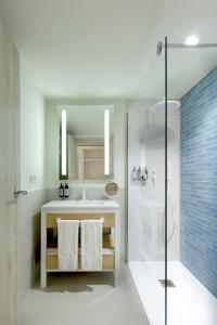 a bathroom with a white sink and a shower at Palladium Hotel Menorca in Arenal d'en Castell