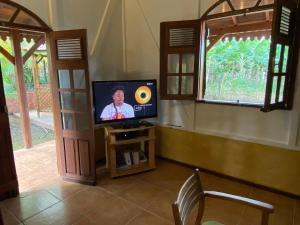 einen TV in einem Zimmer mit Fenster in der Unterkunft Magnifique Lodge en bois avec piscine et jardin de 800 m2 in Le Lamentin