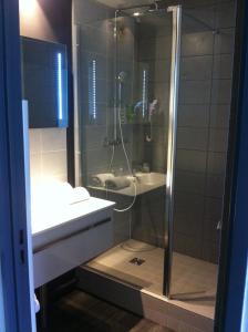 La salle de bains est pourvue d'une douche et d'un lavabo. dans l'établissement Golf Hotel Colvert - Room Service Disponible, à Levernois