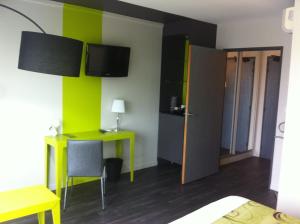 Habitación con escritorio y habitación con paredes verdes. en Golf Hotel Colvert - Room Service Disponible, en Levernois