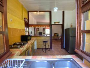 eine Küche mit einer Spüle und einem Herd Top-Backofen in der Unterkunft Magnifique Lodge en bois avec piscine et jardin de 800 m2 in Le Lamentin