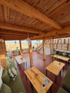 una sala de estar con techos de madera y mesas de madera. en Cozy Surf House, en Taghazout