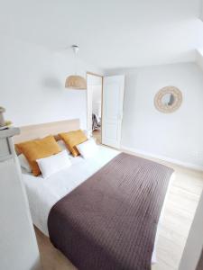 1 dormitorio con 1 cama grande con manta marrón en L'Escale cocooning T3 Centre ville, en Bagnères-de-Bigorre