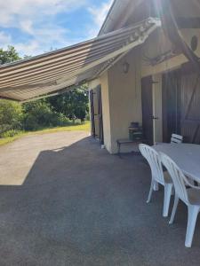 une table et des chaises assises à l'extérieur d'un bâtiment dans l'établissement Gîte à la ferme du Lomont, 