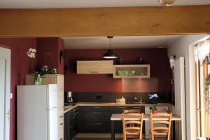 a kitchen with a table and a white refrigerator at Gîte à la ferme du Lomont 