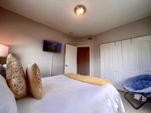 1 dormitorio con 1 cama blanca y 1 silla azul en Marlins Park Suites - Apartment 1 - Calle Ocho Suite, en Miami