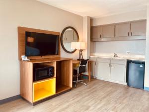 a room with a television and a desk with a chair at Days Inn by Wyndham Ardmore in Ardmore