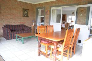 a living room with a wooden table and chairs at 24 on Karee in Stilbaai