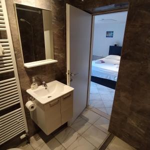 La salle de bains est pourvue d'un lavabo, d'un miroir et d'un lit. dans l'établissement Zana Apartments, à Stari Grad