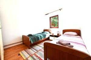 a bedroom with two beds and a rug at Holiday Home Matan in Saborsko