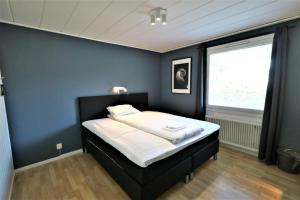 1 dormitorio con 1 cama con pared azul en RIBO Apartment Arctic, en Kiruna