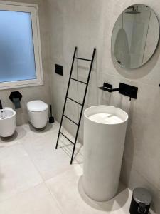 un baño con inodoro y espejo en La Maison del Bell'Antonio - Catania downtown, en Catania 23 fotos más