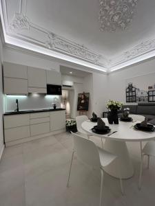 Una cocina y una sala de estar con mesa y sillas. en La Maison del Bell'Antonio - Catania downtown, en Catania