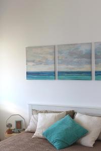 a bedroom with three paintings on the wall above a bed at MareNostrum in Pieve Ligure