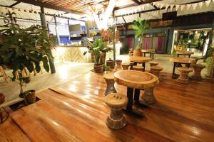a room with tables and stools on a wooden floor at Above The Sea Maesariang in Mae Sariang