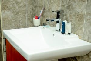 a white sink in a bathroom with a toothbrush at Kim Hotel in Kigali