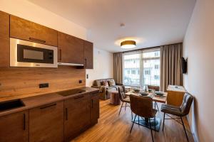 a kitchen and living room with a table and chairs at Rustika - Appartements & Spa in Ehrwald