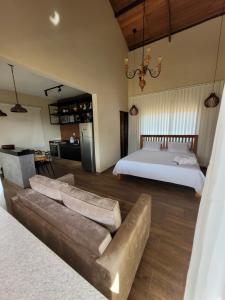 a living room with a couch and a bed at Euetu na Lapinha da Serra in Santana do Riacho