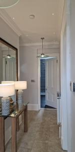 um corredor com uma mesa, um espelho e uma porta em No 9 retreat em Prestwick