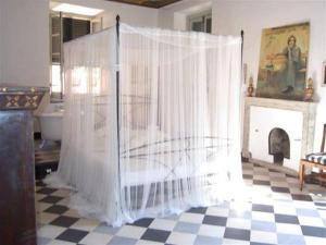 un letto con tende bianche in una stanza con camino di Impero Luxury Apartment a Levanto