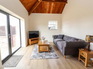 a living room with a couch and a tv at Wren cottage in Sandbach