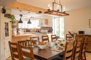 cocina y comedor con mesa de madera y sillas en Maison de L'Anse aux oies / Gîte, en L'islet Sur Mer