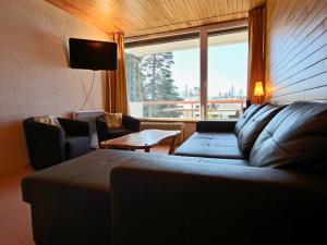 - un salon avec un canapé et une grande fenêtre dans l'établissement Appartement Chamrousse, 3 pièces, 8 personnes - FR-1-549-70, à Chamrousse