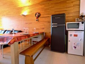 cocina con mesa, microondas y nevera en Appartement Chamrousse, 3 pièces, 8 personnes - FR-1-549-70 en Chamrousse