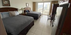 a hotel room with two beds and a balcony at Ramada Marco Polo Beach in Miami Beach