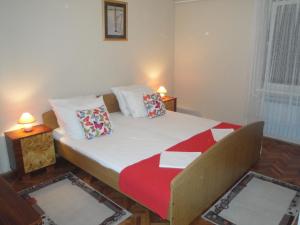 a bedroom with a bed with a red and white blanket at Apartments Vesna G. in Šilo