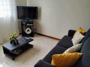 a living room with a blue couch and a tv at Quinta dos Brazilaves - Ponte de Lima in Ponte de Lima