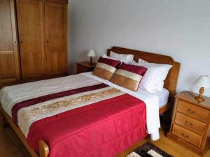 a bedroom with a large bed with a red blanket at Quinta dos Brazilaves - Ponte de Lima in Ponte de Lima