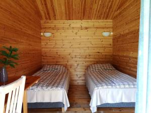 um quarto com 2 camas num chalé de madeira em Tika Farmstay em Kõrkvere