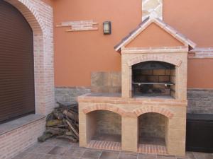 a brick pizza oven on the side of a house at Casa Rural La Calderina in Urda