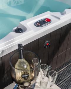a bottle of wine and glasses on a table at Parke -HotTub- Apartment in Pembroke Dock