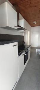 a kitchen with white cabinets and a stove at Apartments Bosnic in Prizba