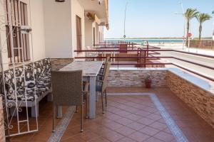 een patio met een tafel en stoelen en uitzicht op het strand bij El Rincón de Soraya in Sanlúcar de Barrameda