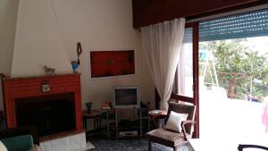 sala de estar con chimenea y TV en Kely, en Kineta