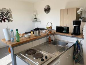 uma cozinha com um lavatório e um fogão em Appartement chaleureux , cosy, bien équipé et bien placé em Sedan