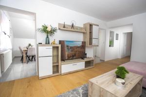 a living room with a tv and a table at Apartman ANDREA in Vinkovci