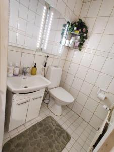 a white bathroom with a toilet and a sink at Cozy and Spacious Row House in Turku
