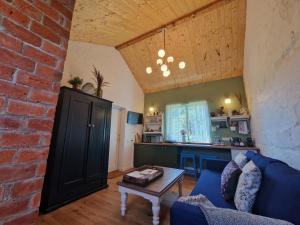 a living room with a blue couch and a brick wall at Pieninė in Ventė